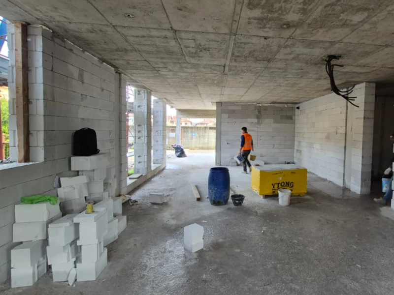 operai-che-lavorano-ad-un-nuovo-edificio-con-pareti-in-cemento